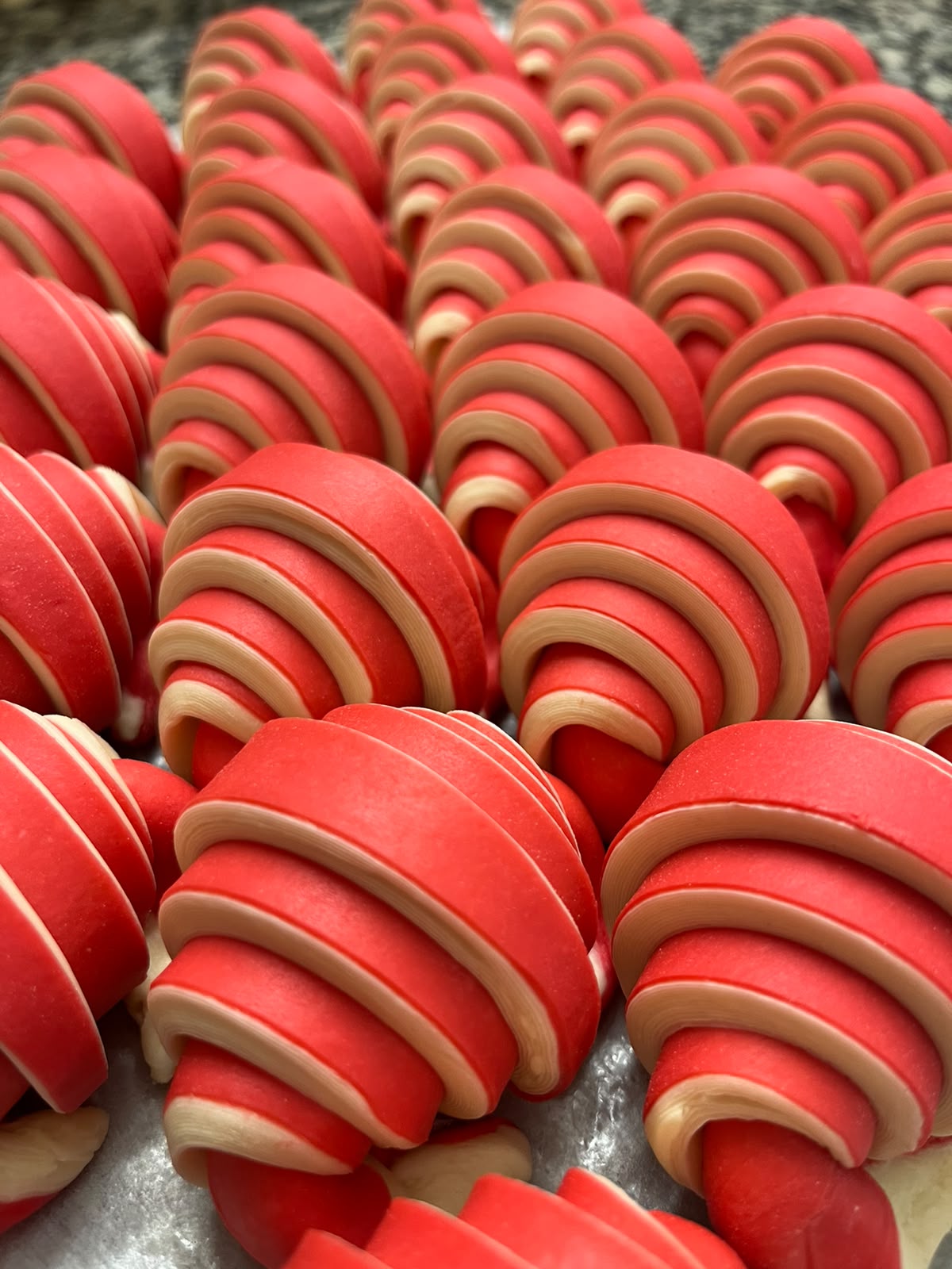 Viennoiseries feuilletées au glaçage rouge, en rangs serrés