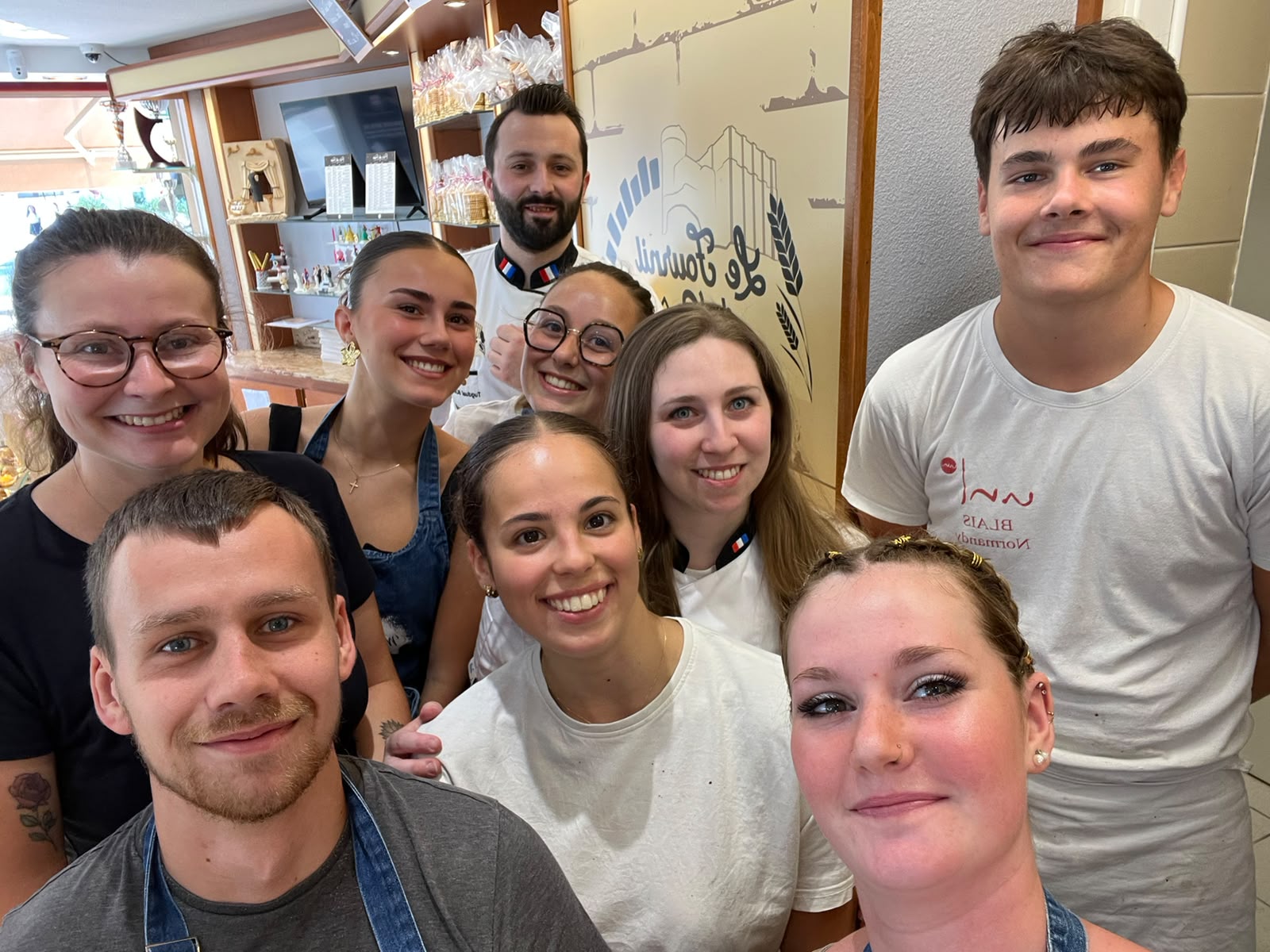 L'équipe de la boutique réunie derrière le comptoir, souriante