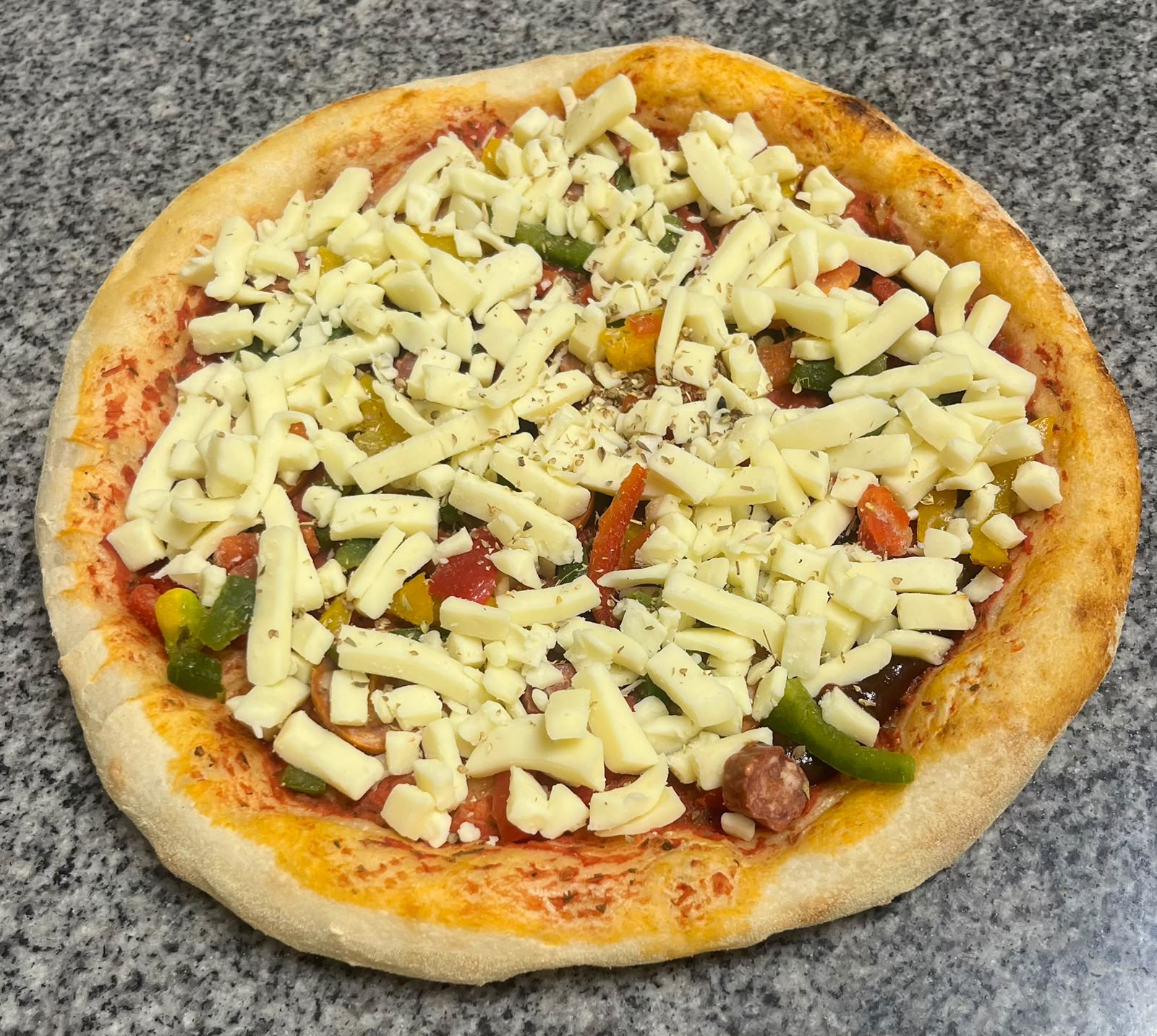Pizza cannibale crue : poivrons, merguez, chorizo et sauce barbecue, garnie au fournil