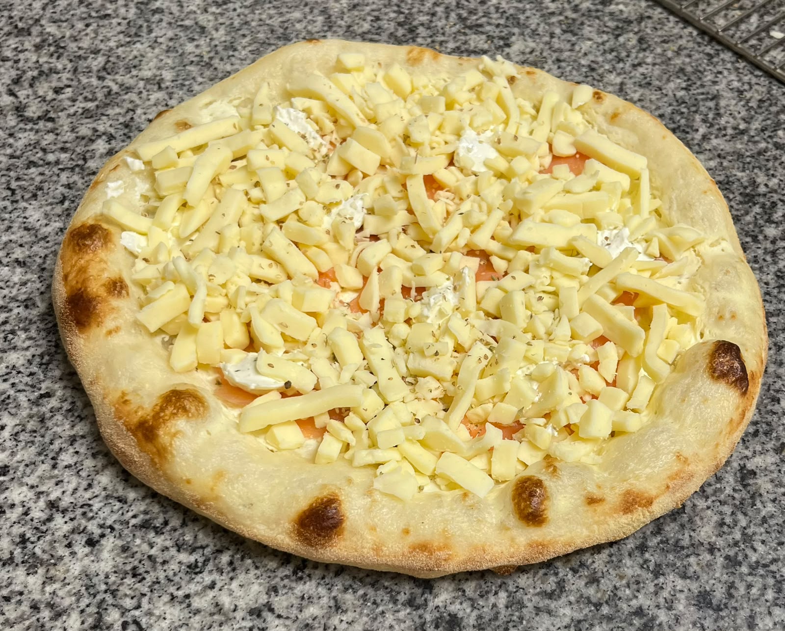 Pizza saumon crue : saumon fumé, fromage ail et fines herbes et mozzarella, garnie au fournil